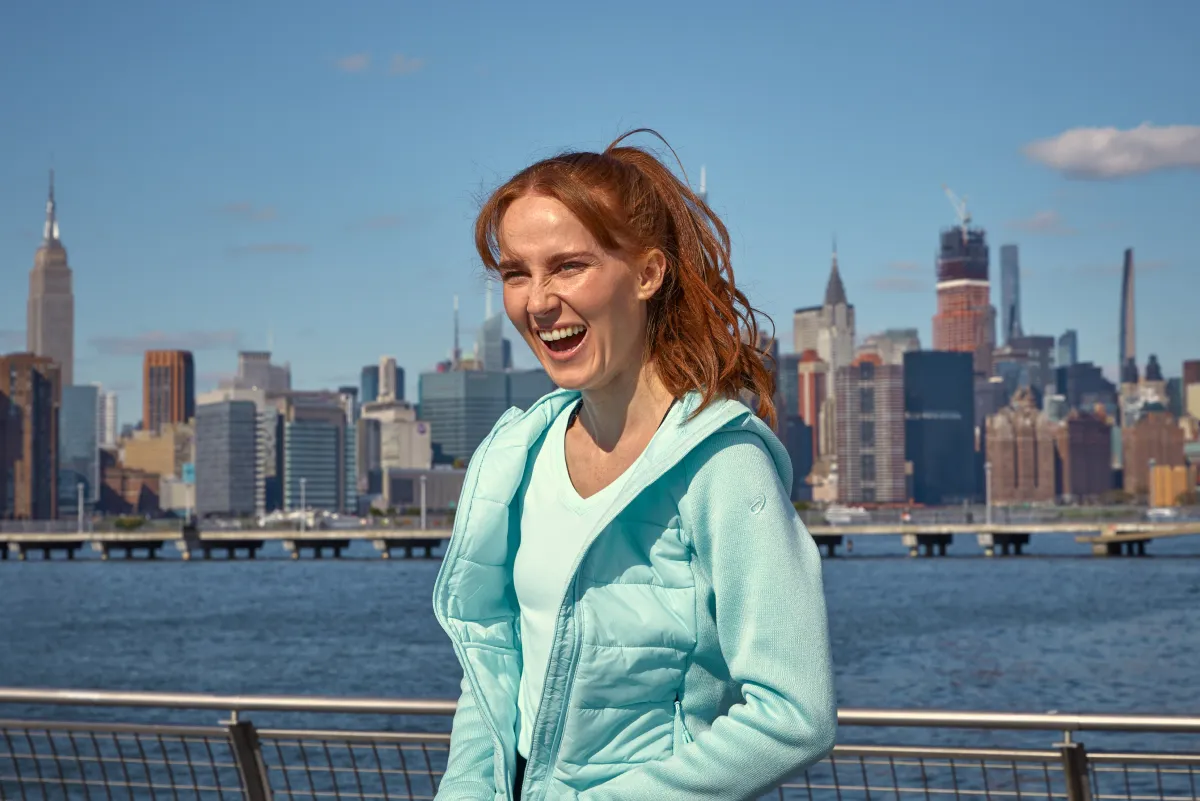 ASICS Athlete laughing in front of a city skyline