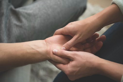 Two people seated together during an AromaTouch Hand Technique experience