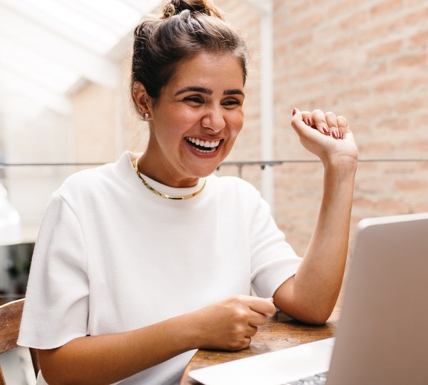 Wellness Advocate celebrating at her laptop