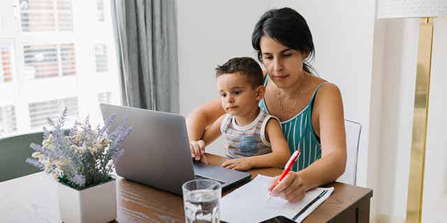Mother with young child studying how payments affect your credit score