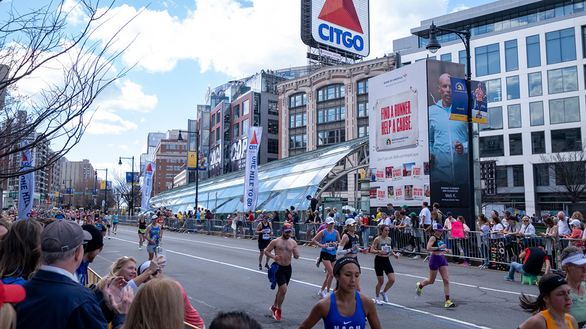 Boston Marathon 2024 competitors run in front of OUTFRONT’s Kenmore Tower and a Bank of America campaign for the Boston Marathon