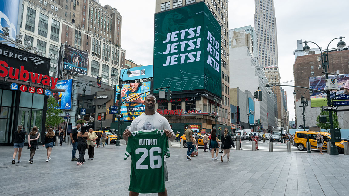 Bart Scott with OUTFRONT Jets jersey next to Penn Digital spectacular