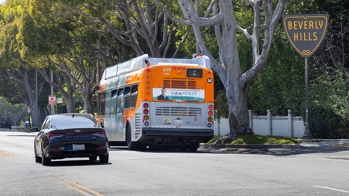 Los Angeles bus with advertising on sides and back entering Beverly Hills