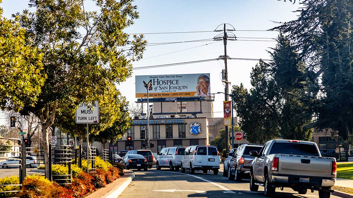 Hospice of San Joaquin bulletin above tree-lined Sacramento street