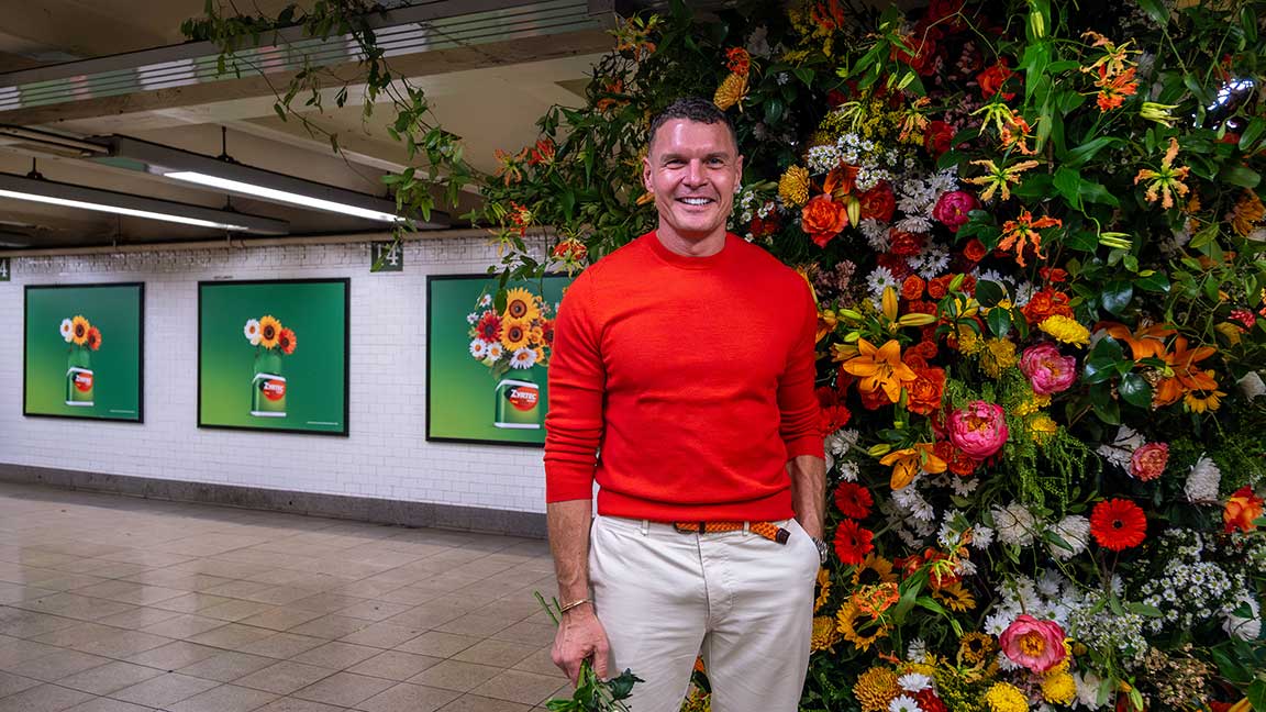 Lewis Miller in front of Flower Flash for Zyrtec at NYC’s 14th Street-Union Square subway station with two-sheet posters behind