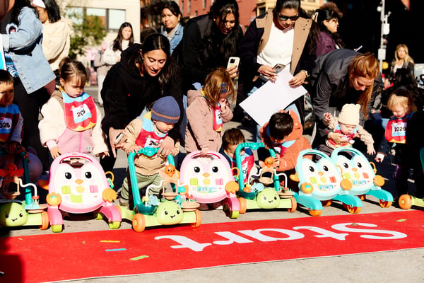 Babies with Fisher-Price walkers on the Mini Marathon course in New York