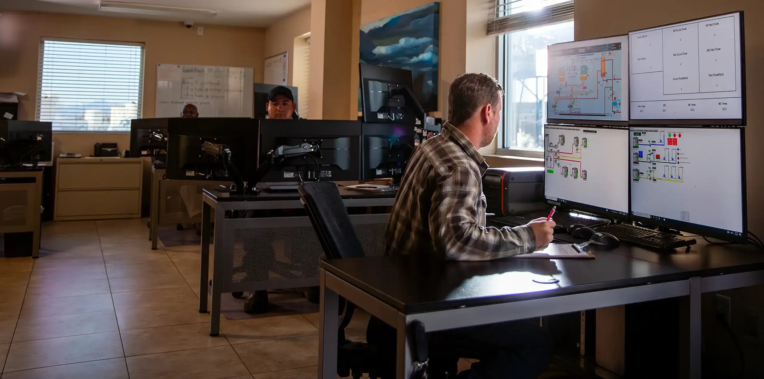 man sitting at desk analyzing computer screens