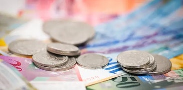 CHF bills with CHF coins on top of it