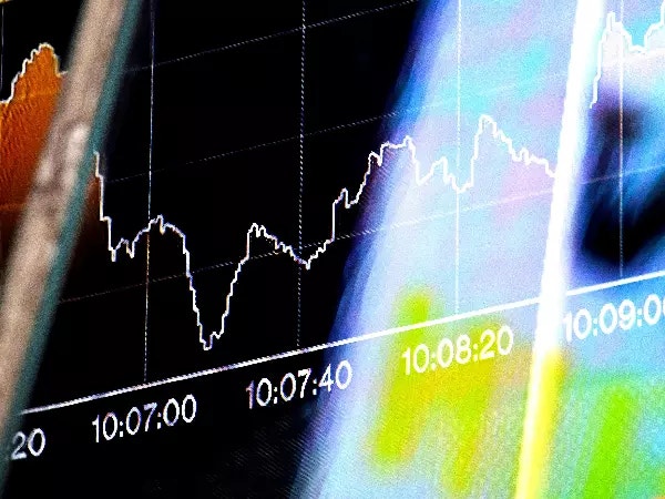 Trading screen with line graph charts and market tickers.