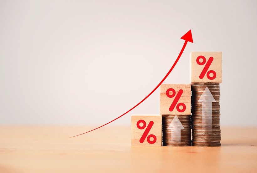 coins stacked with percentage signs and a trending up arrow