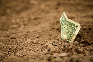 US dollar bill in the dirt