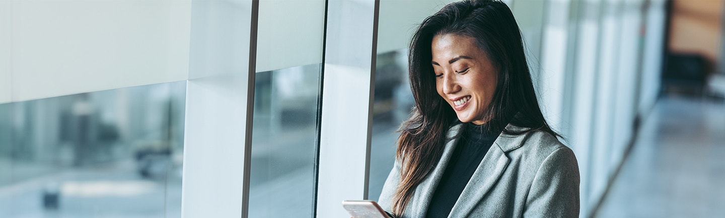 Woman smiling and looking down at phone