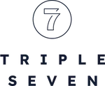 Triple Seven cannabis flower packaging in a sleek black pouch with a vibrant rainbow gradient top, displayed on a dark stone surface beside two buds of cannabis.