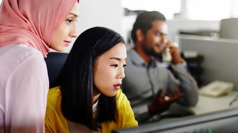 Women in front of a computer looking at Korean courses with Berlitz Algeria