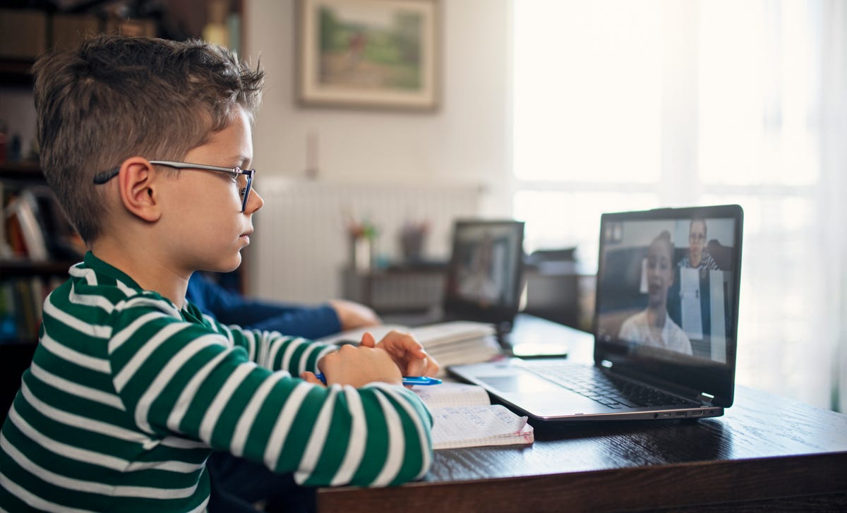 Boy attending an online language class with his instructor from his laptop