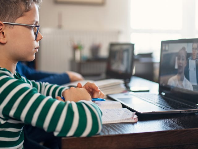 Boy attending an online language class with his instructor from his laptop
