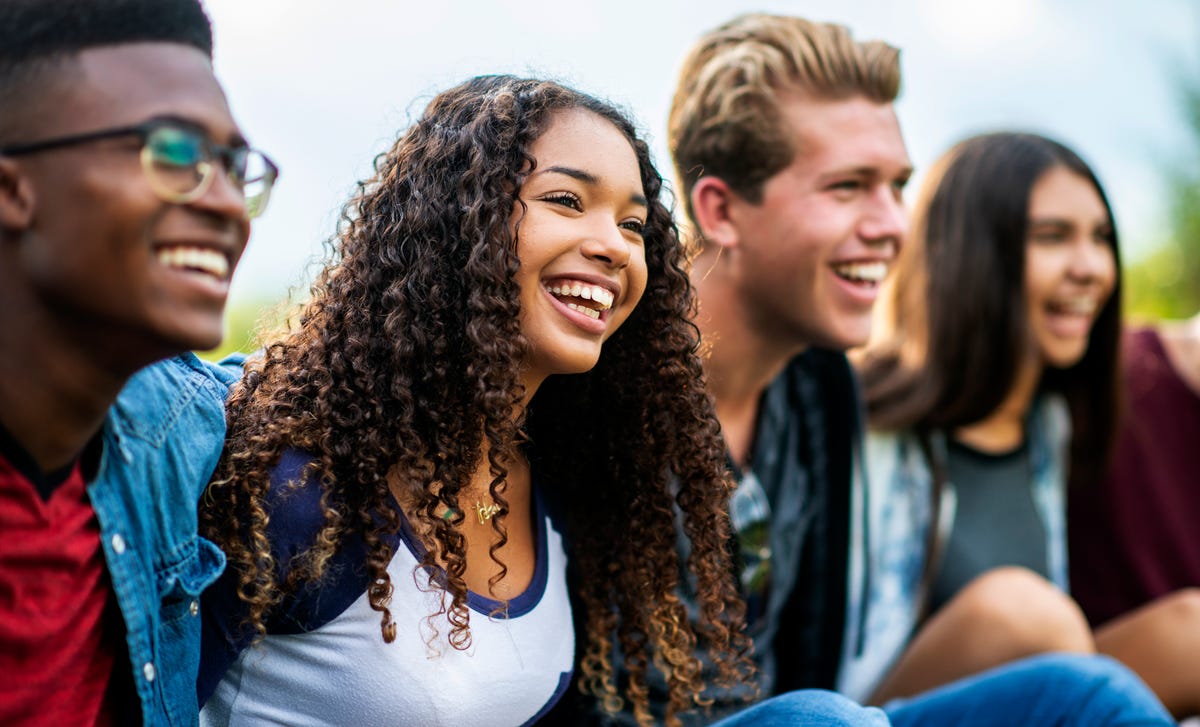 Group of teenagers talking and laughing together after their French class with Berlitz