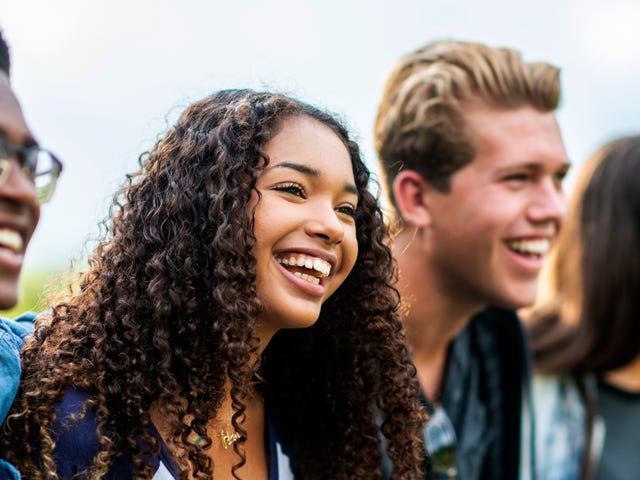 Group of teenagers talking and laughing together after their French class with Berlitz