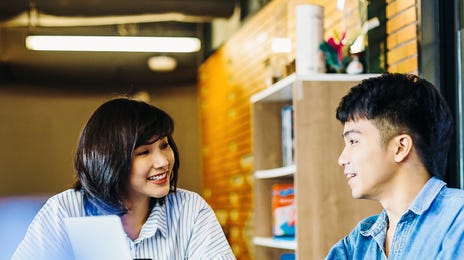 A Berlitz instructor talking to her student in his target language