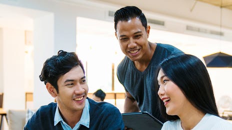 Two students in a charter learning a foreign language from their instructor