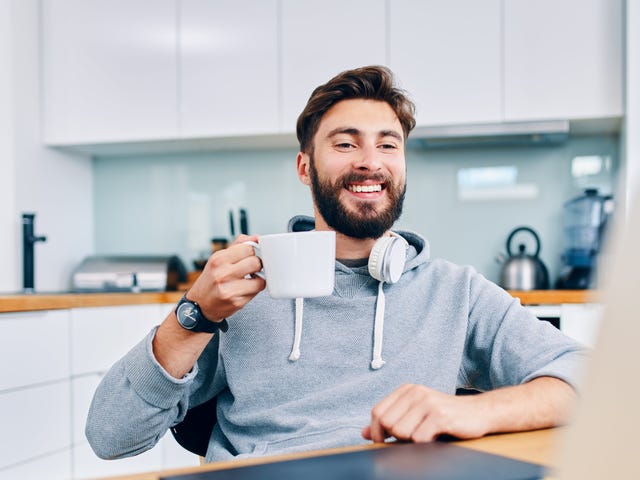 Man drinking coffee during an intensive language class he's attending from his laptop