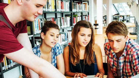 Group of teenagers in front of a laptop looking at Arabic courses with Berlitz