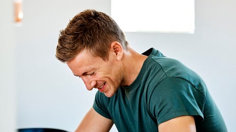 Man taking notes during a IELTS preparation course and smiling