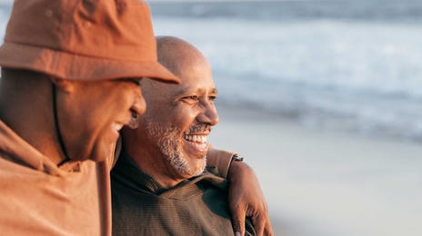 Men on the seashore laughing and talking to each other in Portuguese