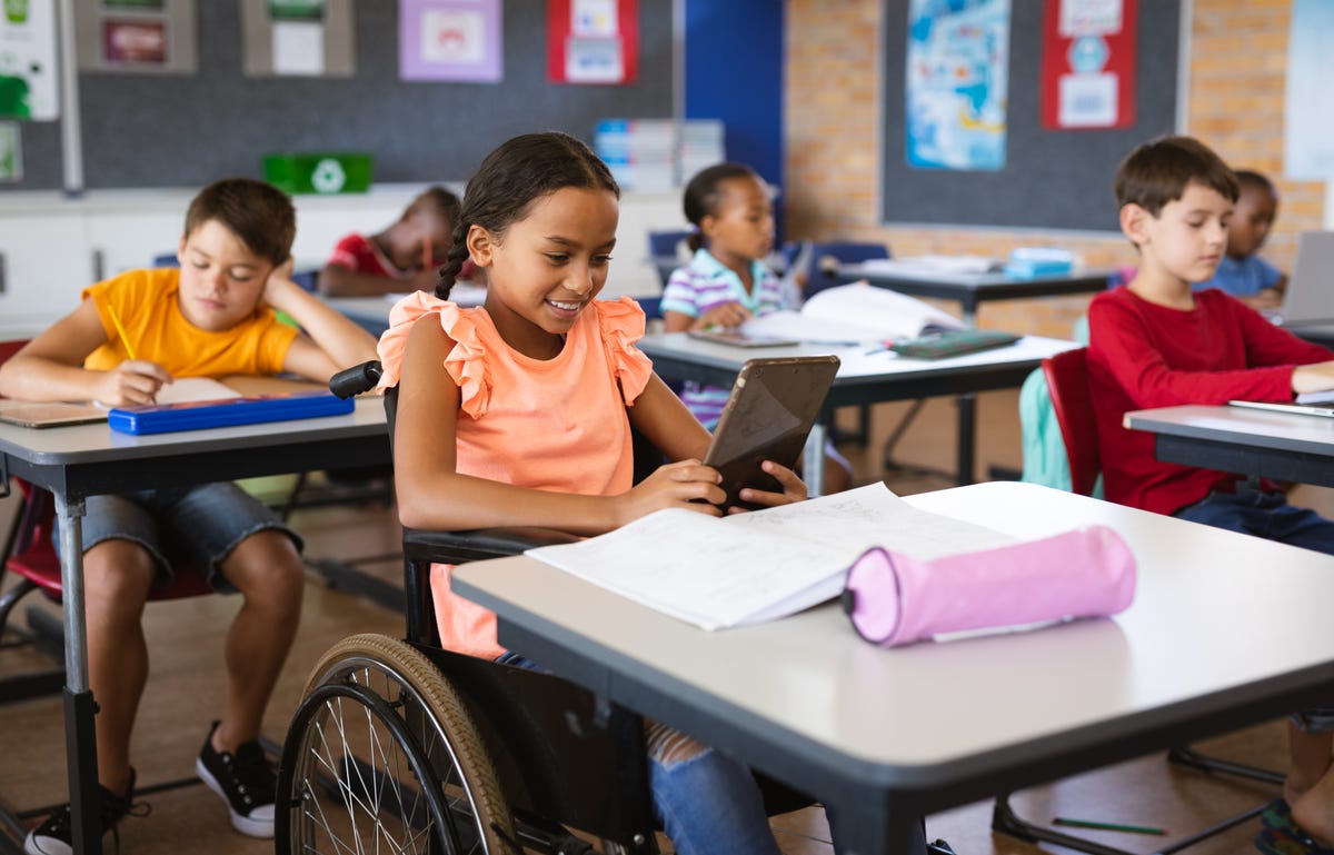 Girl in a wheelchair looking at her tablet while attending a language class for kids with Berlitz Algeria