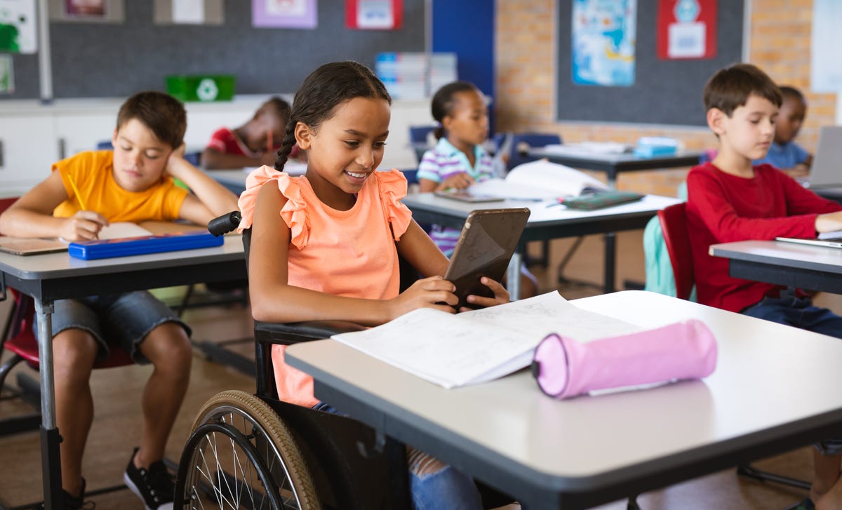 Girl in a wheelchair looking at her tablet while attending a language class for kids with Berlitz Algeria