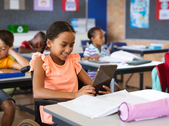 Girl in a wheelchair looking at her tablet while attending a language class for kids with Berlitz Algeria