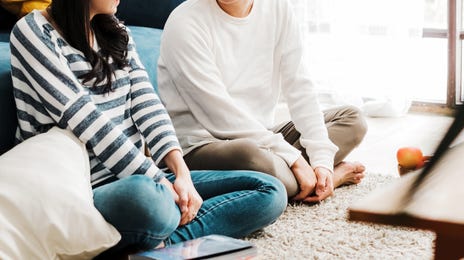Student and instructor sitting on the rug and talking before their TOEFL preparation course