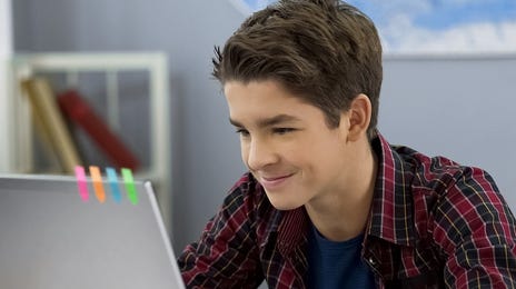 Kid attending an online German class with Berlitz from his laptop