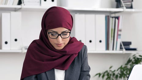 Woman attending and online English course with Berlitz Algeria from her laptop and making notes