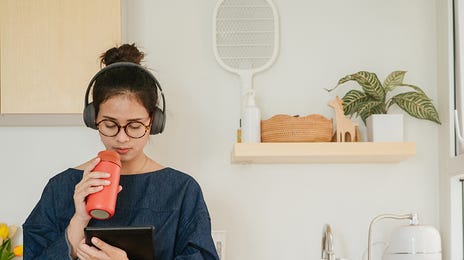 Woman attending an online English class with Berlitz Algeria and drinking water from a bottle
