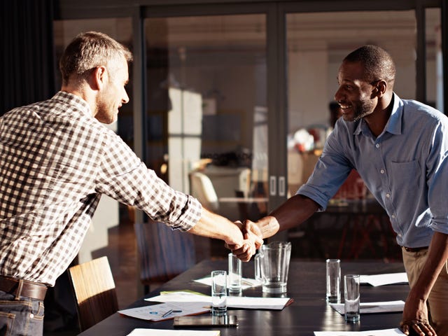 Two men shaking hands after one successfully gets a job at Berlitz Algeria