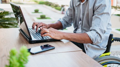 Man sitting outside and attending a Korean class with Berlitz from his computer