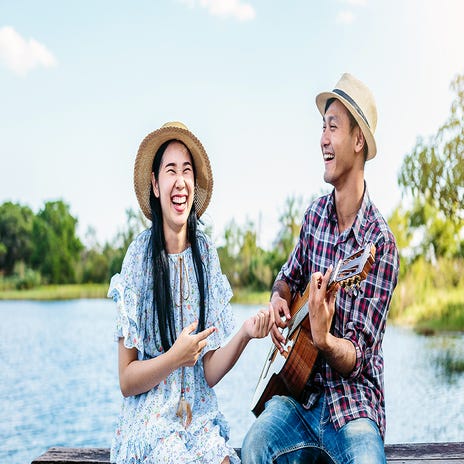 Man playing the guitar to his girlfriend and singing in Japanese