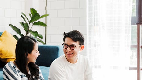 Student sitting on the floor next to a couch and learning Mandarin