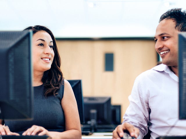 Man and woman sitting next to each other and attending an online intensive language class with Berlitz from their computers
