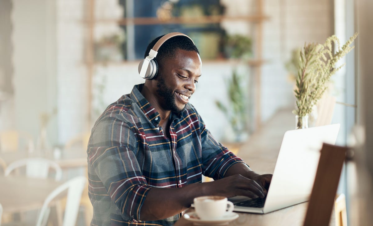 Man in headphones learning Arabic online on his laptop with Berlitz Algeria's language classes