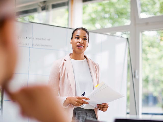 Instructor standing in front of a white board and using the Berlitz Method during an intensive language class