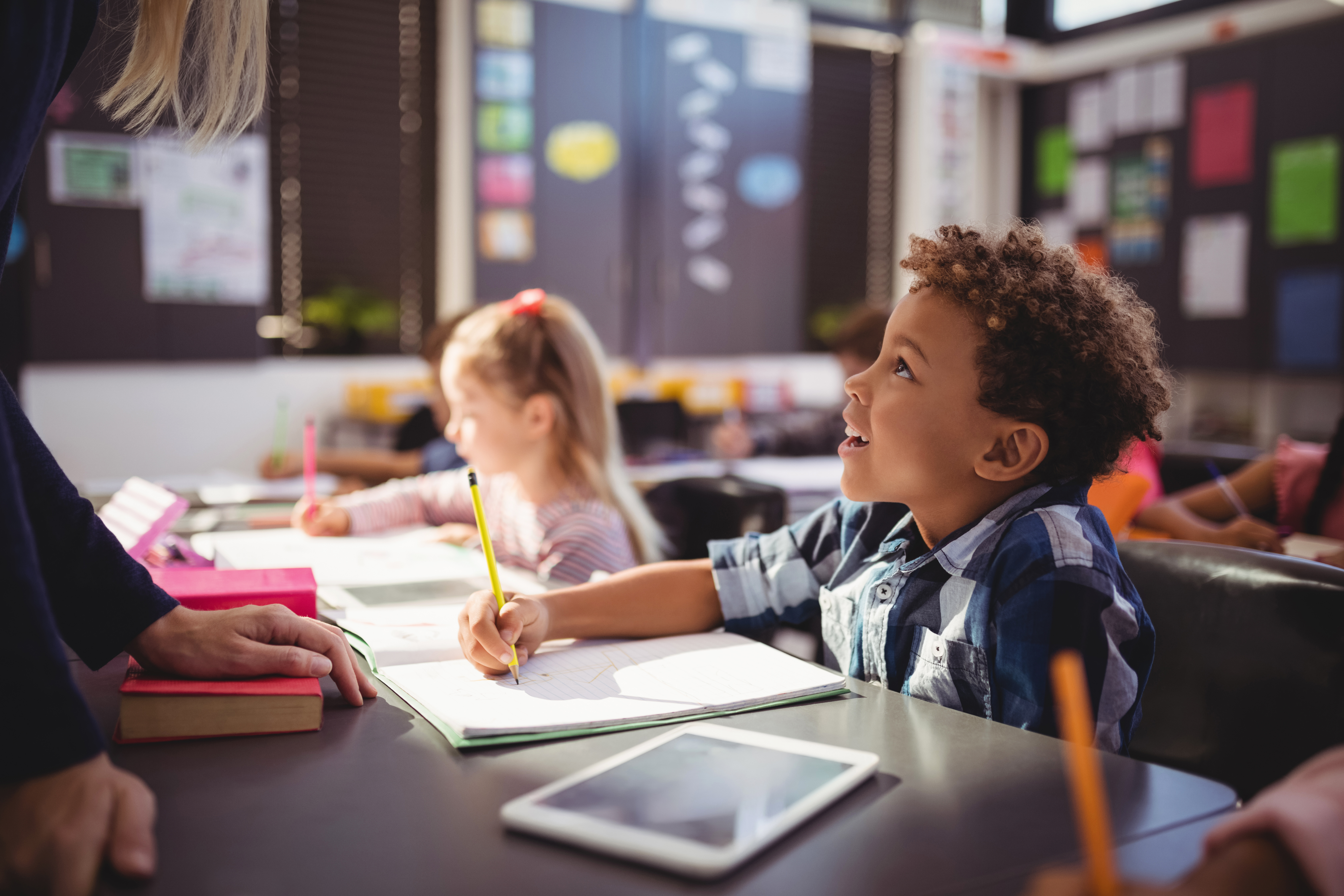 Boy making notes during his English course for kids and teens with Berlitz