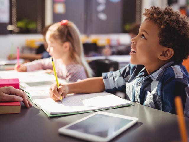 Boy making notes during his English course for kids and teens with Berlitz