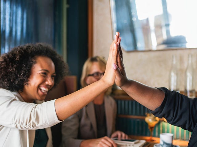 Student drinking coffee and giving each other a high-five after their Arabic class for beginners