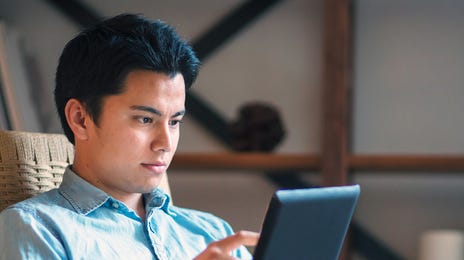 Man holding a tablet and learning a language by practicing with Berlitz Flex