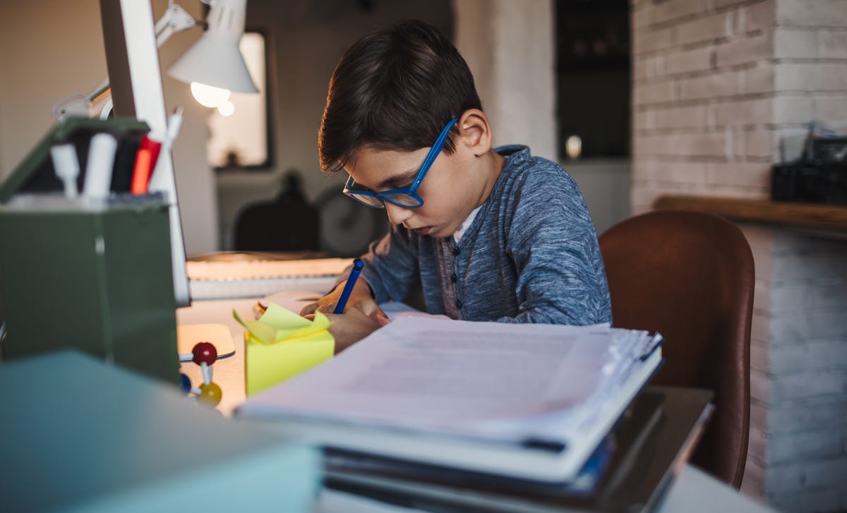 Boy in glasses doing his homework for his Spanish class with Berlitz Algeria