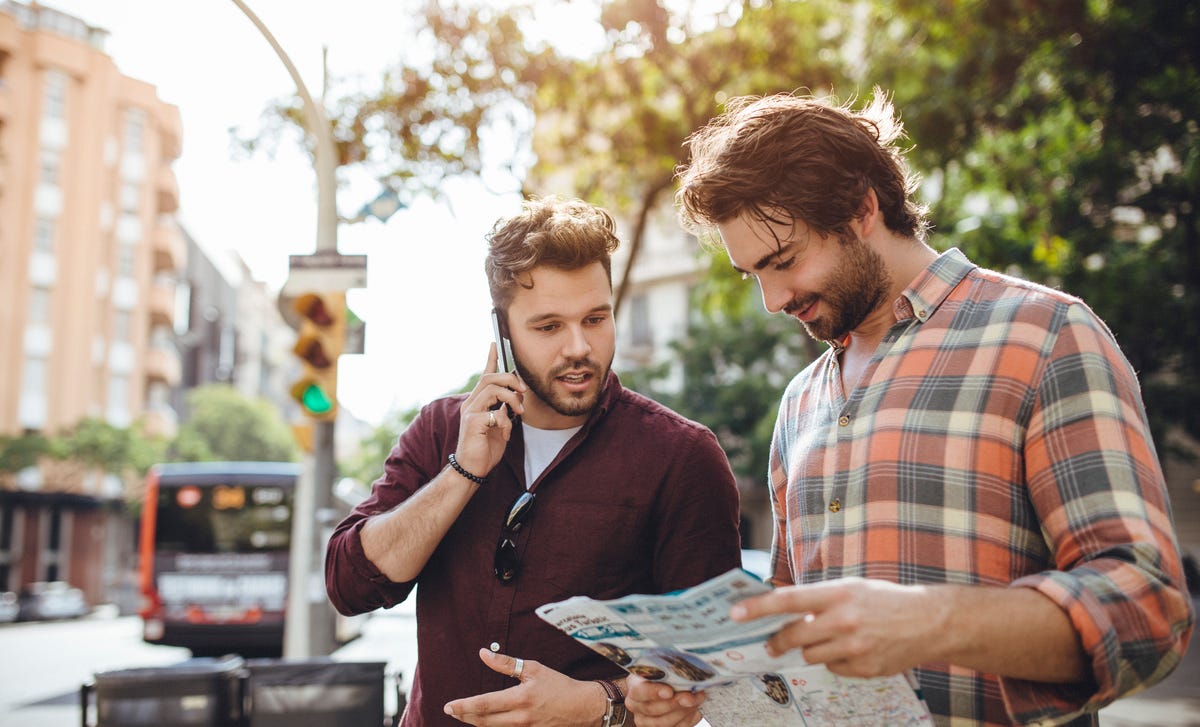 Men looking at a map and chatting in French after their French class with Berlitz Algeria