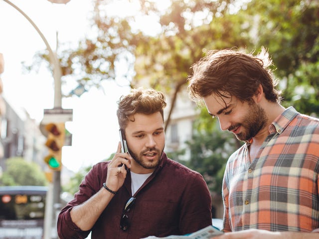 Men looking at a map and chatting in French after their French class with Berlitz Algeria
