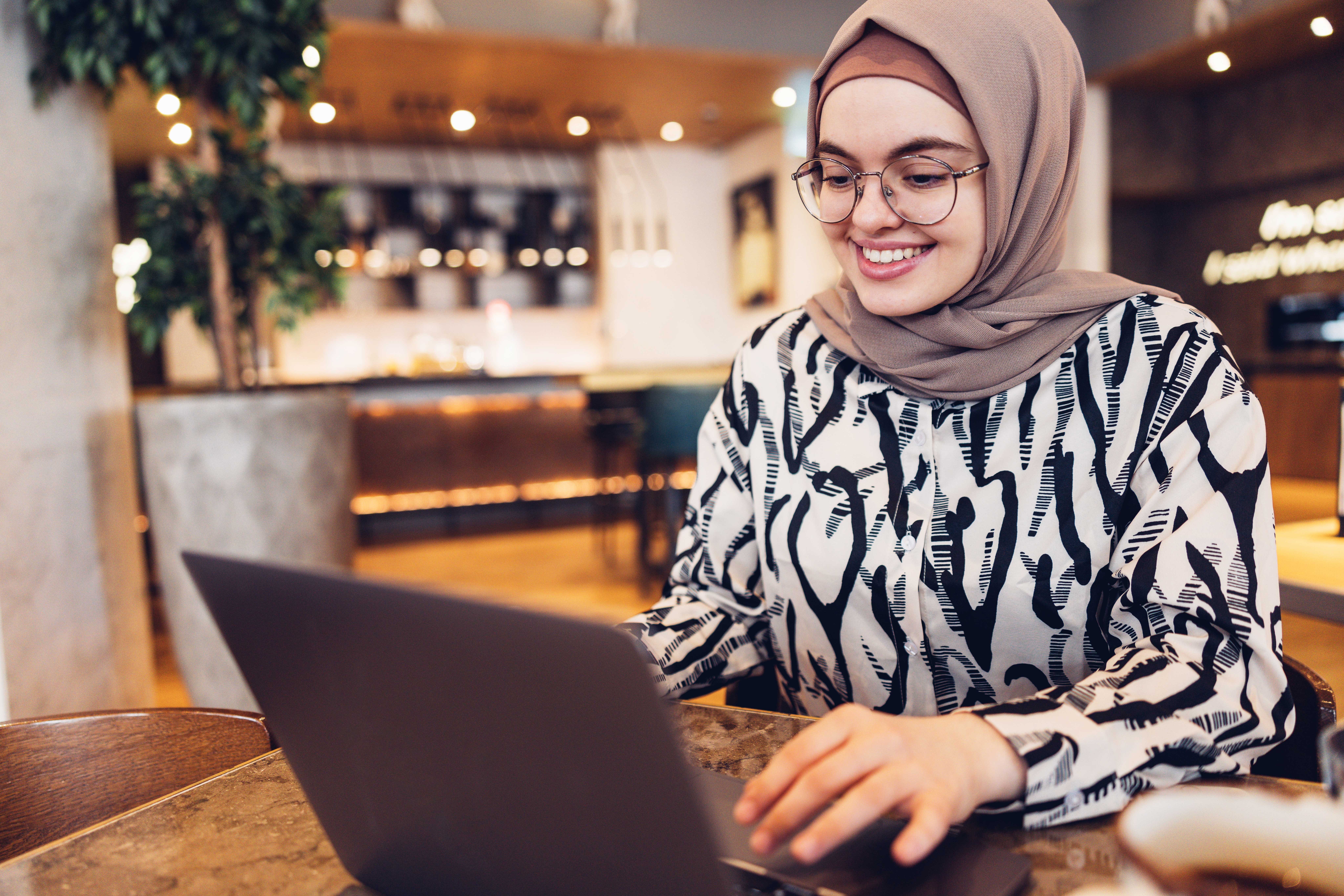 Woman taking an intermediate English class with Berlitz Algeria from her laptop
